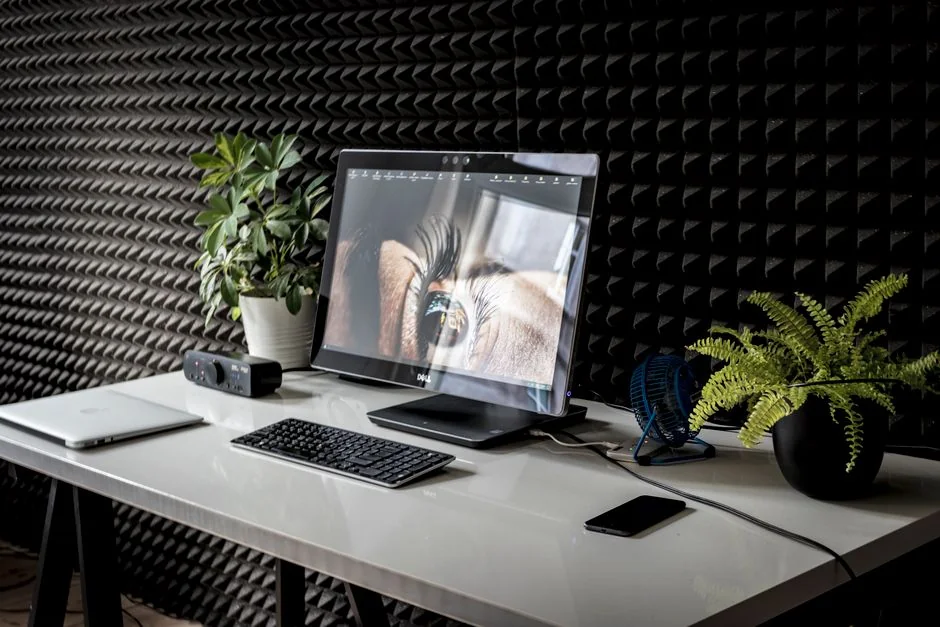 A contemporary computer display showing web design work and creative visuals in a workspace.